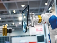industrial automated robot arm holding car glass in factory