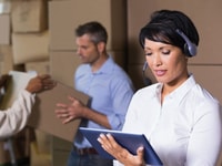 Pretty-warehouse-manager-using-tablet-during-busy-period-in-a-large-warehouse Distribution