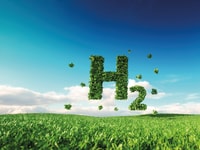 Eco friendly clean hydrogen energy concept. 3d rendering of hydrogen icon on fresh spring meadow with blue sky in background_1092687374