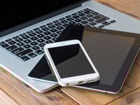 laptop smart phone and a tablet on a wooden table