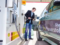 Shell employee at fuel station filling the tank