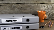 Company and Acquisition - two folders on wooden office desk