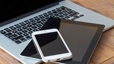 laptop smart phone and a tablet on a wooden table