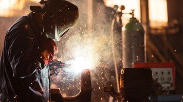 industrial worker at the factory welding