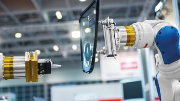 industrial automated robot arm holding car glass in factory