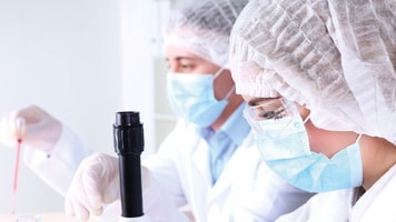 Spec-gases-Laboratory-Male-and-female-scientists-using-microscope-in-laboratory