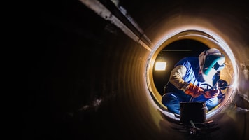 workers welding pipeline