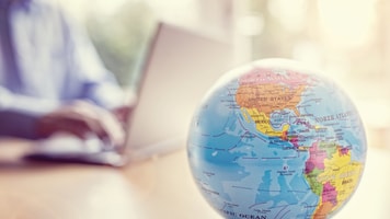 North America-businessman-using-a-laptop-with-globe