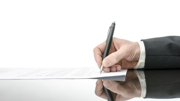 Signing a contract on a black table. With copy space and reflection_129508757