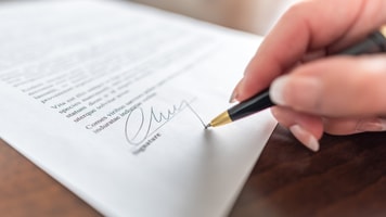 Woman hand signing a contract_310318895