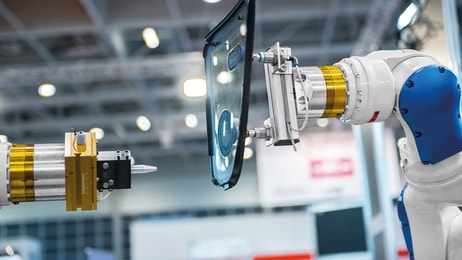 industrial automated robot arm holding car glass in factory