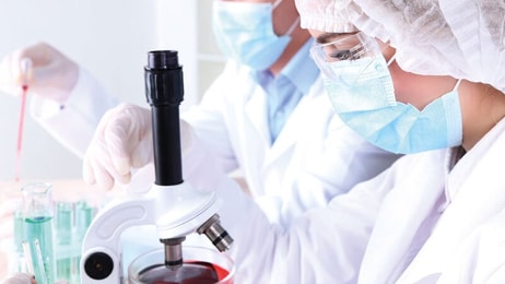 Spec-gases-Laboratory-Male-and-female-scientists-using-microscope-in-laboratory