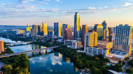 Austin Texas USA sunrise skyline cityscape over Town Lake or Lady Bird Lake with amazing reflection. Skyscrapers and Texas capital building in distance you can see the entire city during summer