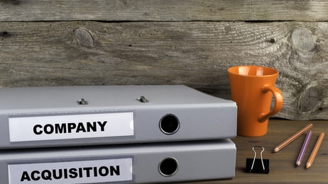 Company and Acquisition - two folders on wooden office desk
